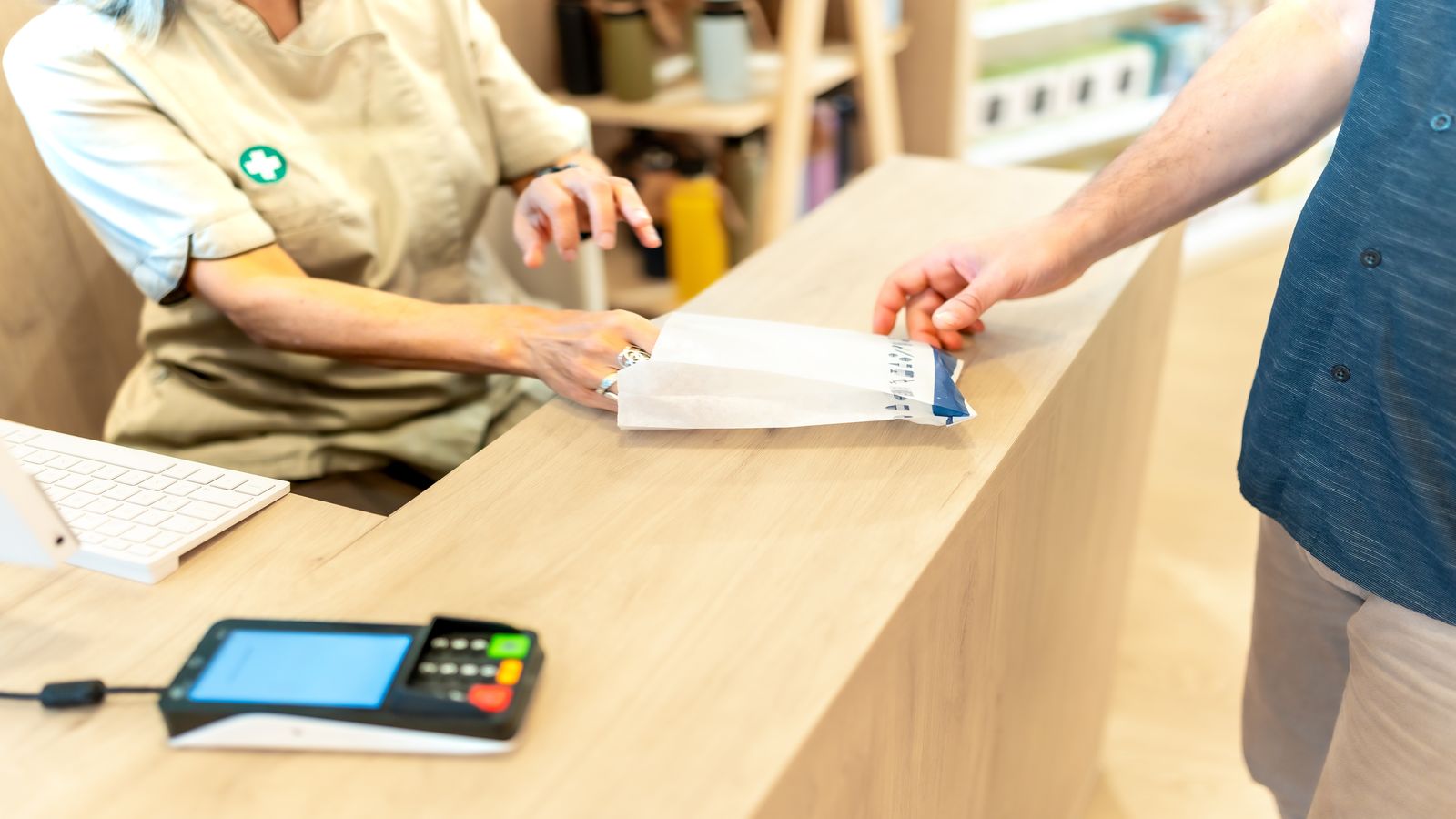 Merchant counter with a returns form, a packaged product, and a tablet showing a refund transaction