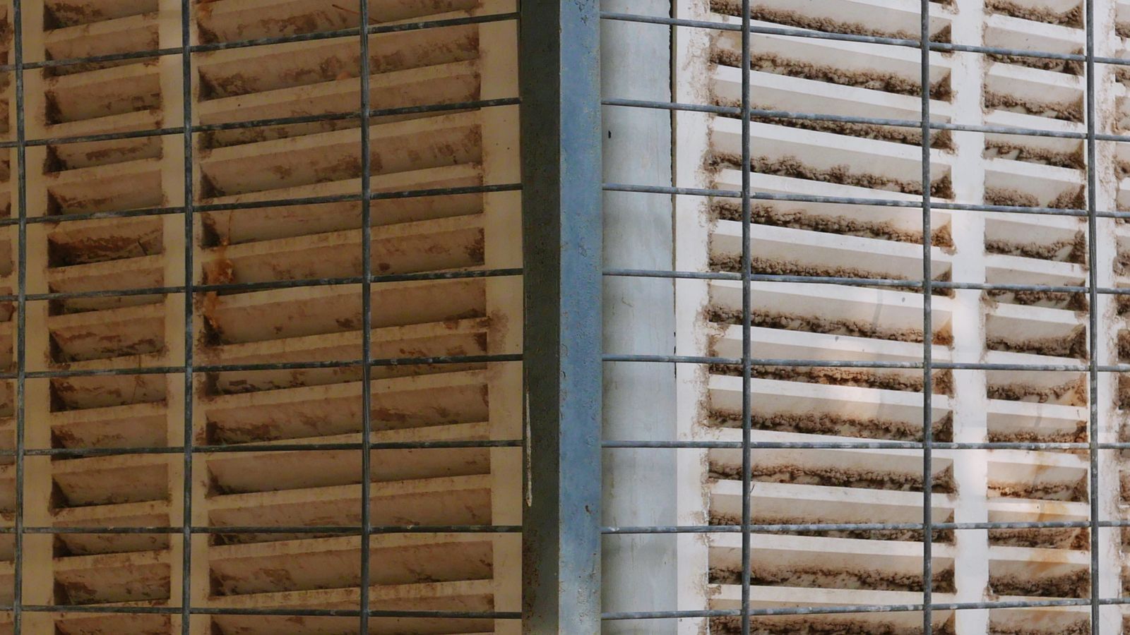 Close-up of greenhouse ventilation ducting with condensation visible on metal surfaces